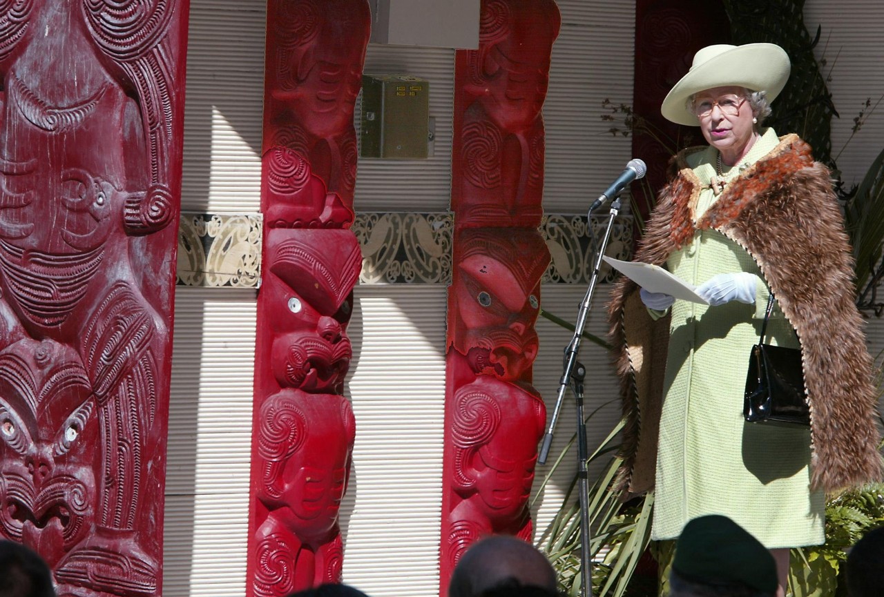 Queen Elizabeth II, wearing the same korowai (a traditional cloak made of kiwi feathers) that she wore during her first royal visit to New Zealand in 1954, speaks to the indigenous Maori people at Rehua Marae in Christchurch, 25 February 2002, during her Golden Jubilee tour.  The British monarch is in New Zealand for five days before travelling to Australia on 27 February to open the Commonwealth Heads of Government Meeting (CHOGM) in Coolum on 02 March.  AFP PHOTO/Torsten BLACKWOOD (Photo by TORSTEN BLACKWOOD / AFP) (Photo by TORSTEN BLACKWOOD/AFP via Getty Images)